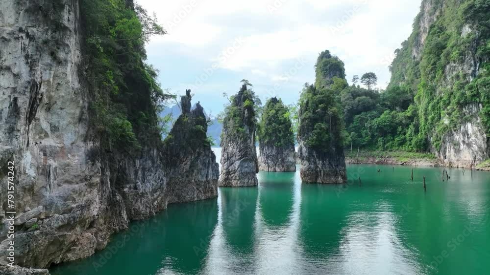The green area at Khao Sok national park Cheow Lan Dam lake with blue sky background in Surat Thani, Thailand. The green area at Khao Sok national park Cheow Lan Dam lake with blue sky background in Surat Thani, Thailand.