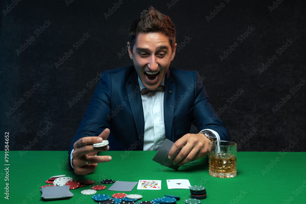 The lucky poker player rejoices at his victory and cannot contain his emotions. The lucky poker player rejoices at his victory and cannot contain his emotions.