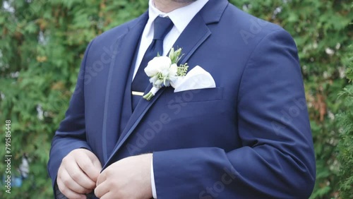 Groom buttons suit before wedding photo