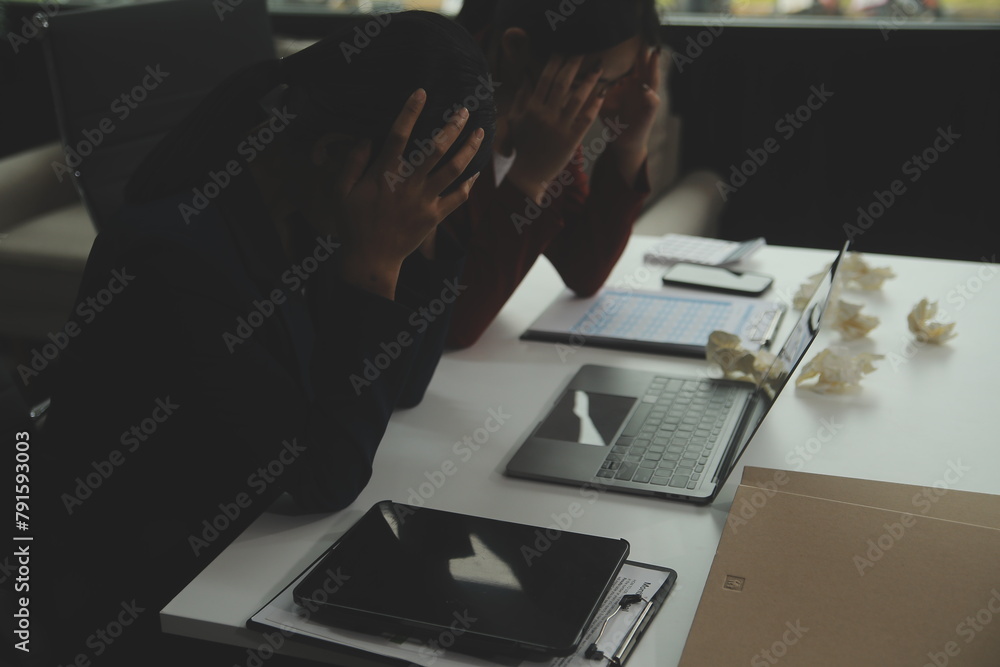 Stressed annoyed office employee manager having headache migraine at business meeting with his colleagues about business problem they have to solve. Stress at work or migraine concept. Stressed annoyed office employee manager having headache migraine at business meeting with his colleagues about business problem they have to solve. Stress at work or migraine concept.