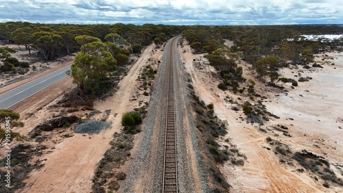 Aerial view of a long railway surrounded by a highway and a salt lake in Western Australia