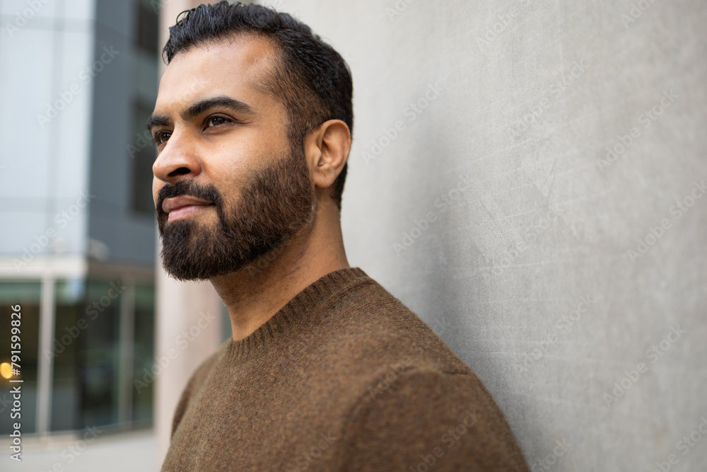 A contemplative man gazes into the distance, his profile captured against the minimalist background of an urban setting A contemplative man gazes into the distance, his profile captured against the minimalist background of an urban setting