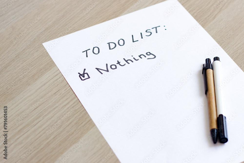 A white blank note or sheet of paper is on a wooden table background. To do list concept with no plans A white blank note or sheet of paper is on a wooden table background. To do list concept with no plans