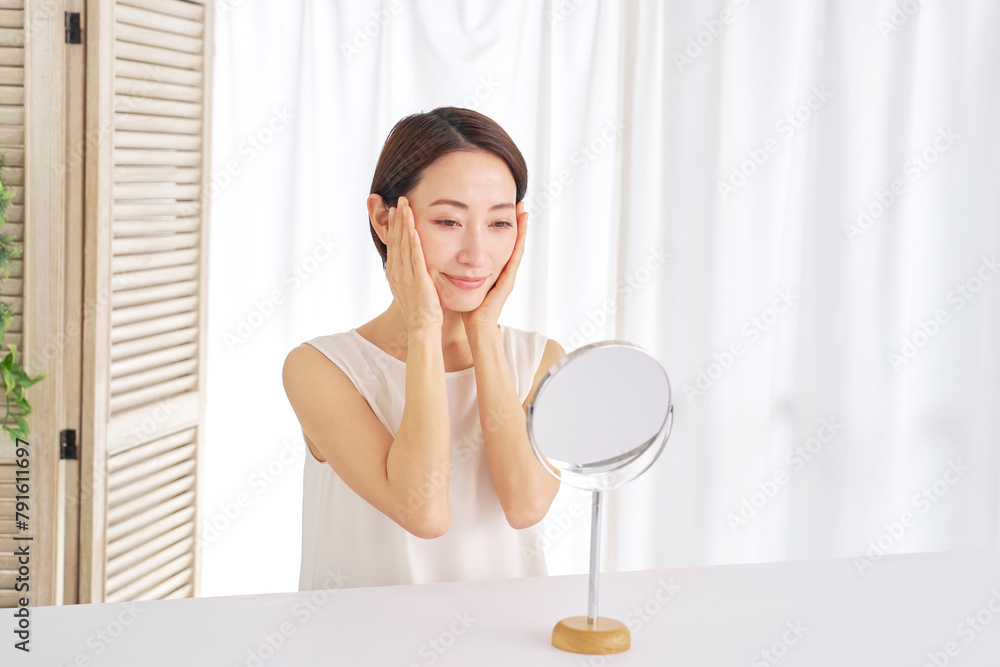 自宅でフェイシャルケアをする中年女性