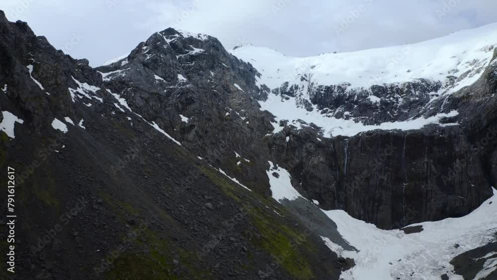 Relaxing descent from mountain peak to glacier valley in Fiordland, New Zealand, South Island, pan right aerial Relaxing descent from mountain peak to glacier valley in Fiordland, New Zealand, South Island, pan right aerial