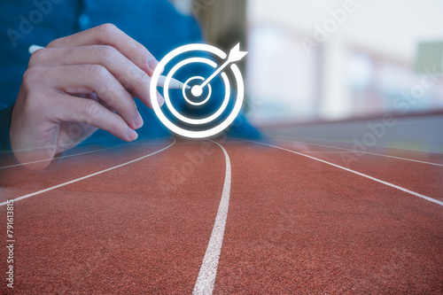 Business goal and target concept, businessman using pen drawn on arrow dart to virtual target dart board with running track background multi exposure