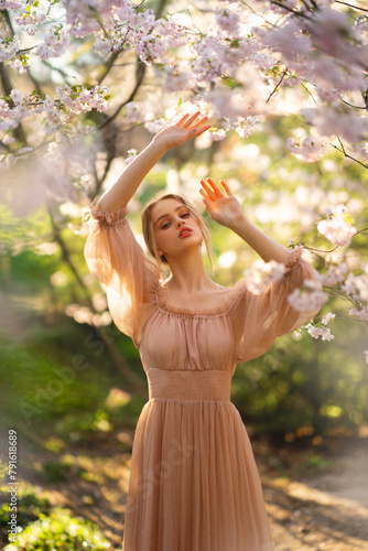 Beautiful  girl in pink  vintage dress  standing near colorful flowers. Art work of romantic woman .Pretty tenderness model posing with emotions.