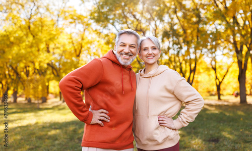 Portrait of happy senior husband and wife in sportive outfits play sports outdoors in city park.