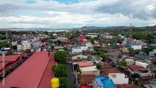 Binangonan, Rizal, Philippines - Mar 29, 2024: Forward flyby Aerial of the Sta. Ursula Parish Church. Metro Manila in the horizon.