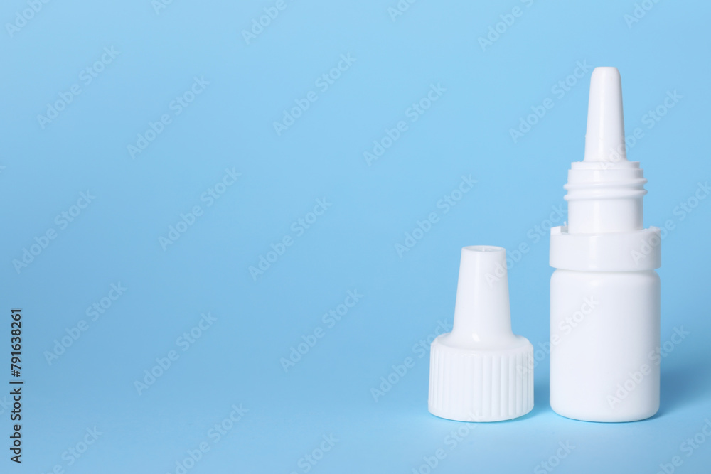 Bottle of medical drops on light blue background, space for text Bottle of medical drops on light blue background, space for text