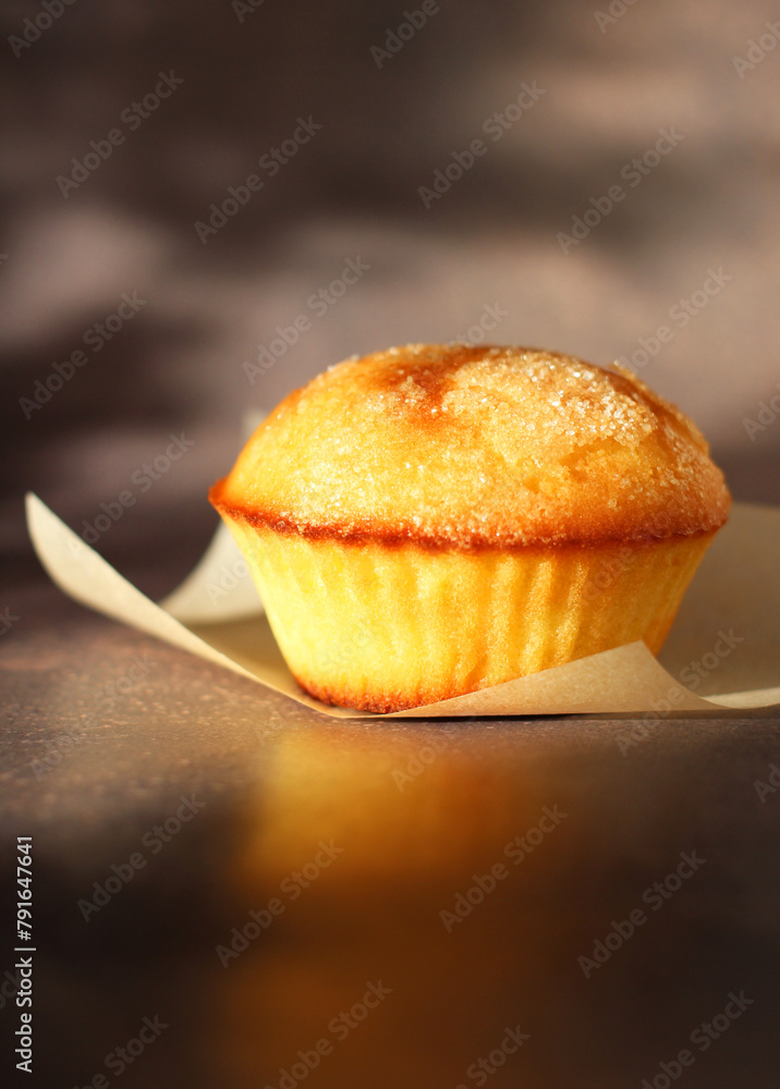 Dessert small cupcake on parchment on dark background Dessert small cupcake on parchment on dark background