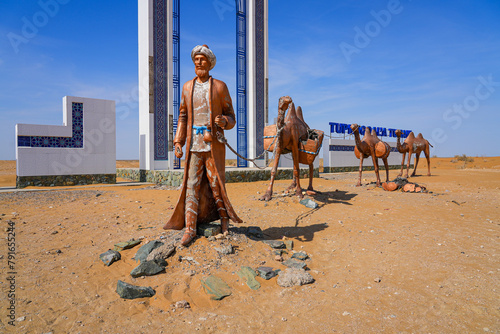 Sculpture of a camel train caravan along the ancient silk road at the gateway to the Khorezm Region of Uzbekistan, located along the A380 highway in the Kyzylkum Desert in Central Asia photo