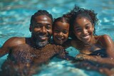 A cheerful family of three shares a playful and affectionate moment together in a sunlit pool