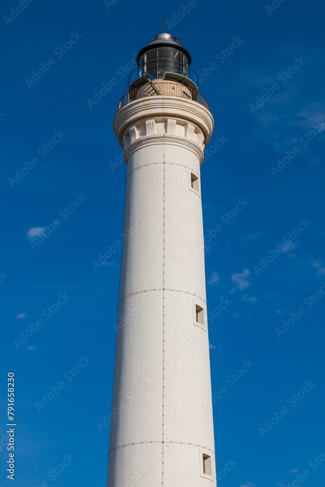 A white lighthouse in a sunny day.