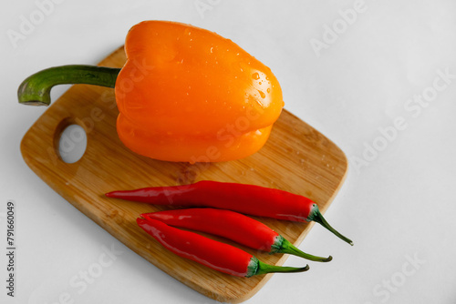 Red chilli and orange sweet pepper on white background