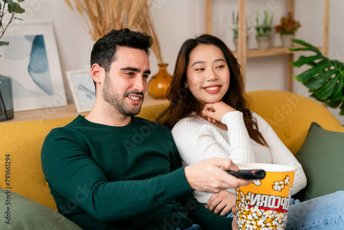 Couple enjoying a movie on the couch with popcorn photo