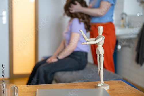 Wooden artist mannequin staged with hands together in a home setting. photo