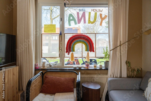 Cozy room with a window showcasing child's artwork. photo