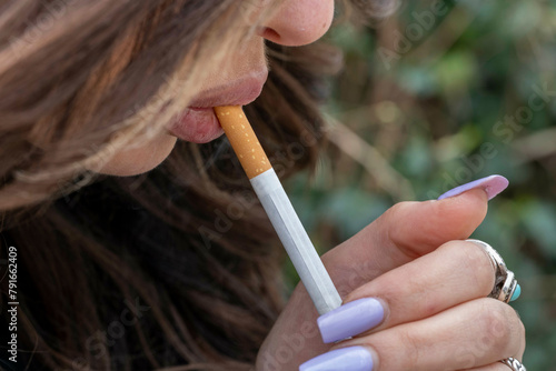 Woman smoking a cigarette outdoors photo