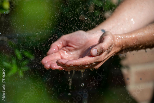 Hands catching splashing water droplets. photo