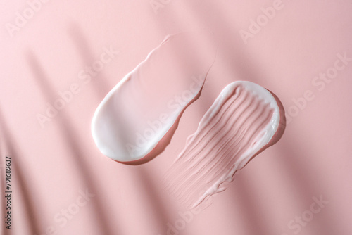 Cosmetic cream textures on a soft pink background