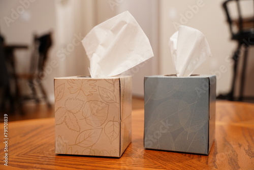 Foto Boxes of Kleenexs sit on a coffee table.
