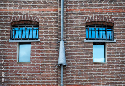Exterior of an old prison building, brick wall and the windows with metal bars