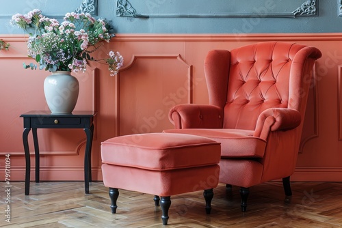 Stylish armchair and ottoman near color wall in room