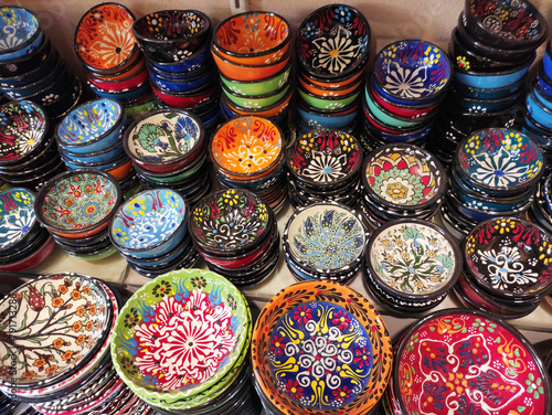 Round plates with multicolored traditional Oriental Arabic ornaments, on the shop window, in the assortment © Mari