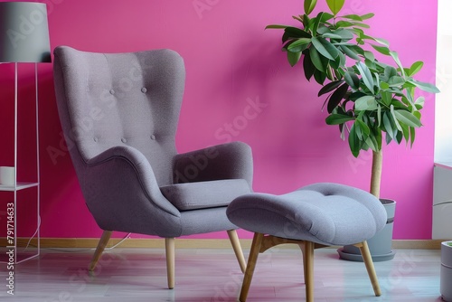 Stylish armchair and ottoman near color wall in room