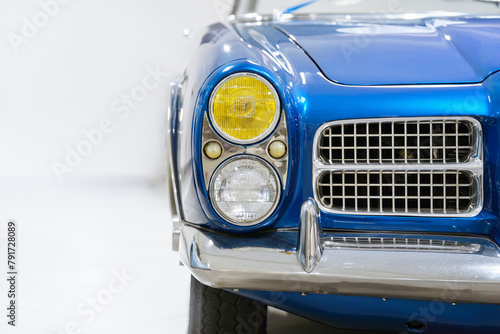 Front view of a blue vintage car. Classic car. Headlights. White background.