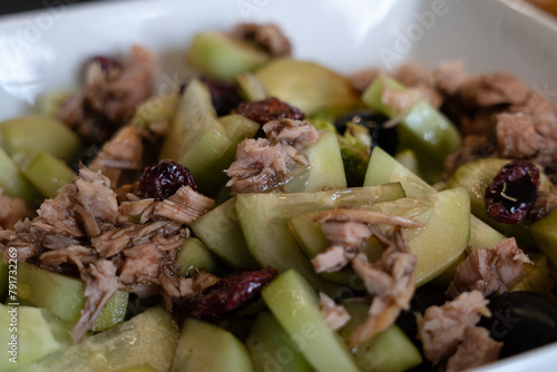 Closeup of cucumber salad with tuna and berries