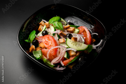 Greek salad of tomato, cucumber, chopped onion,bread croutons, and black olives