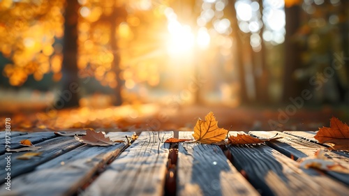 Beautiful empty wooden table with fall leaves, glowing sun set and blurry seasonal colors photo