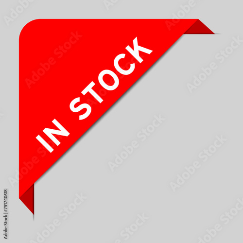 Red color of corner label banner with word in stock on gray background