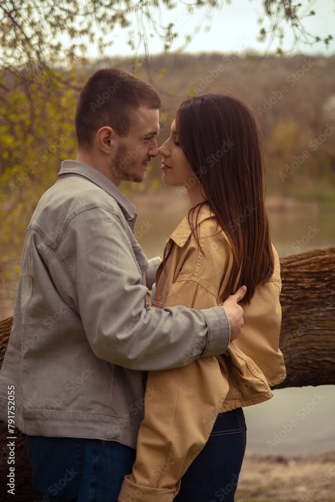 Young love and friendship: a teenage couple embraces by the lake, expressing first feelings and a kiss. Capturing the essence of a first date and romantic meeting spots, Valentine's Day Young love and friendship: a teenage couple embraces by the lake, expressing first feelings and a kiss. Capturing the essence of a first date and romantic meeting spots, Valentine's Day
