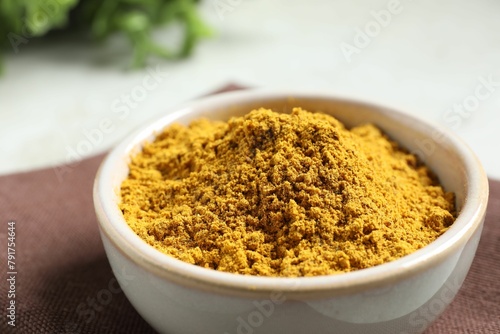 Curry powder in bowl on white table  closeup