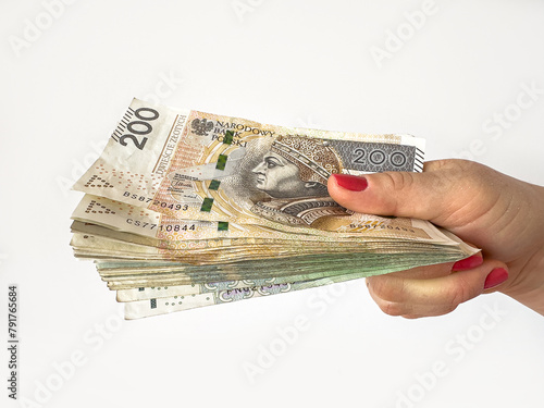 Stack of zl pln Polish zloty banknotes holding in female hand for shopping isolated on white