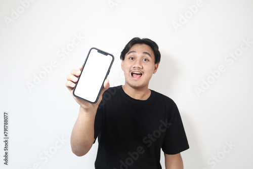 Obraz na płótnie Adult Asian man smiling confident while pointing to empty handphone screen that