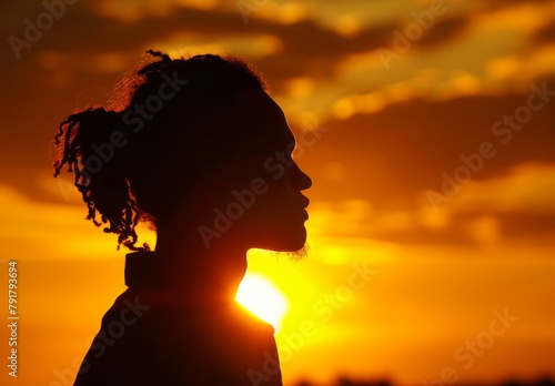 Silhouette against sunset: shadow reflects inner struggles, golden hues represent hope, resilience. photo