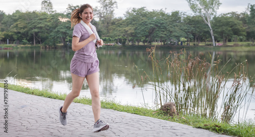 A woman is running in a park near a lake
