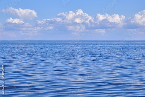 Blue sea and white clouds on sky.