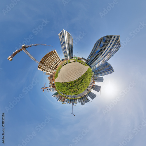 abstract swirling tiny planet spherical panorama of multi-storey buildings of skyscrapers of a residential complex in the form of a butterfly in blue sky