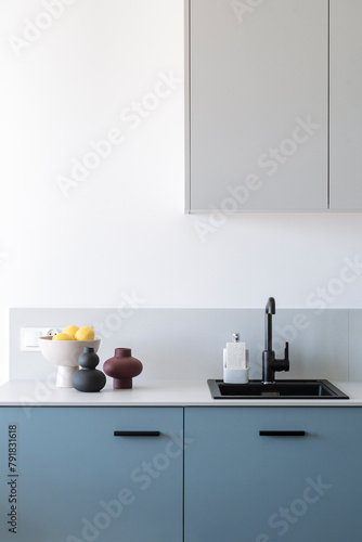 Vertical shot of black ceramic sink with faucet in loft interior in kitchen