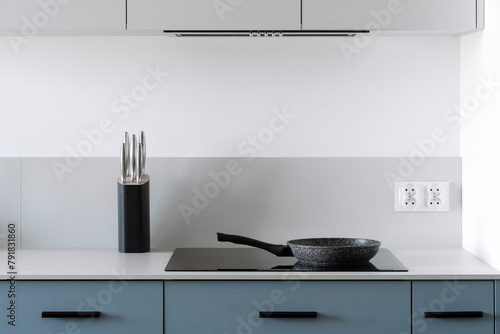 Fotografie Glass ceramic electrical hob with frying pan on kitchen with minimalist style