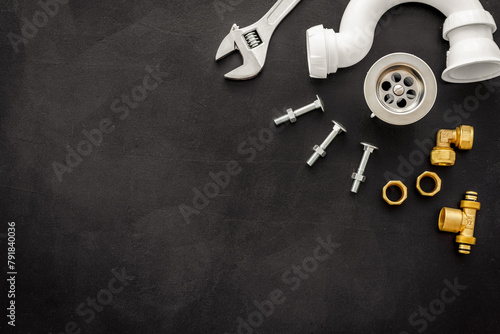 Plumber profession with gear and instruments for repair tubes on black background top view copyspace