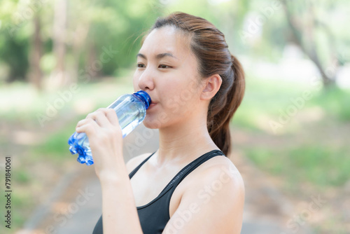 Asian woman drinking water after jogging. Health care concept. Drinking enough water per day.