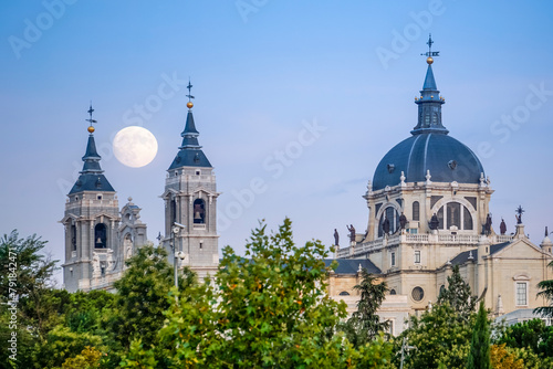 Sunset image of the Almudena Cathedral in Madrid with the full moon in the background photo