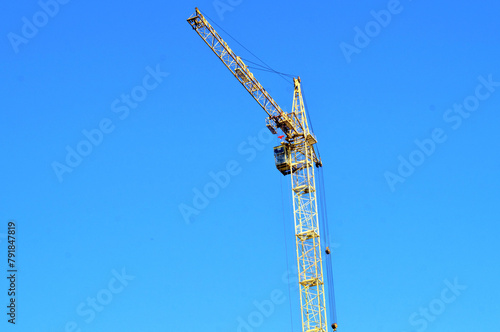 Construction. High-rise tower crane against blue sky
