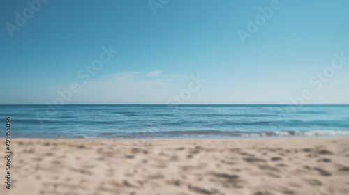 Simple, blurry background of a sandy beach and calm sea.